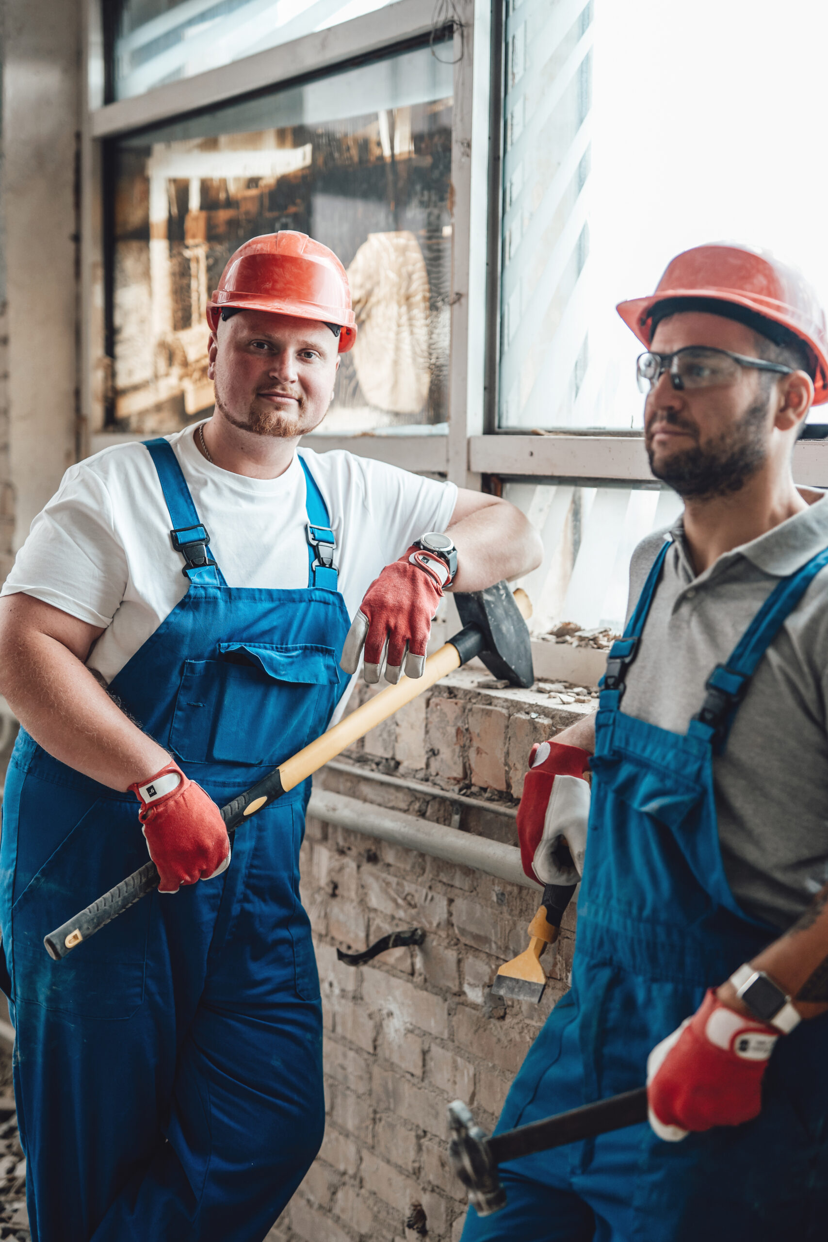a couple of tired workers stand near the brick wall at a construction site